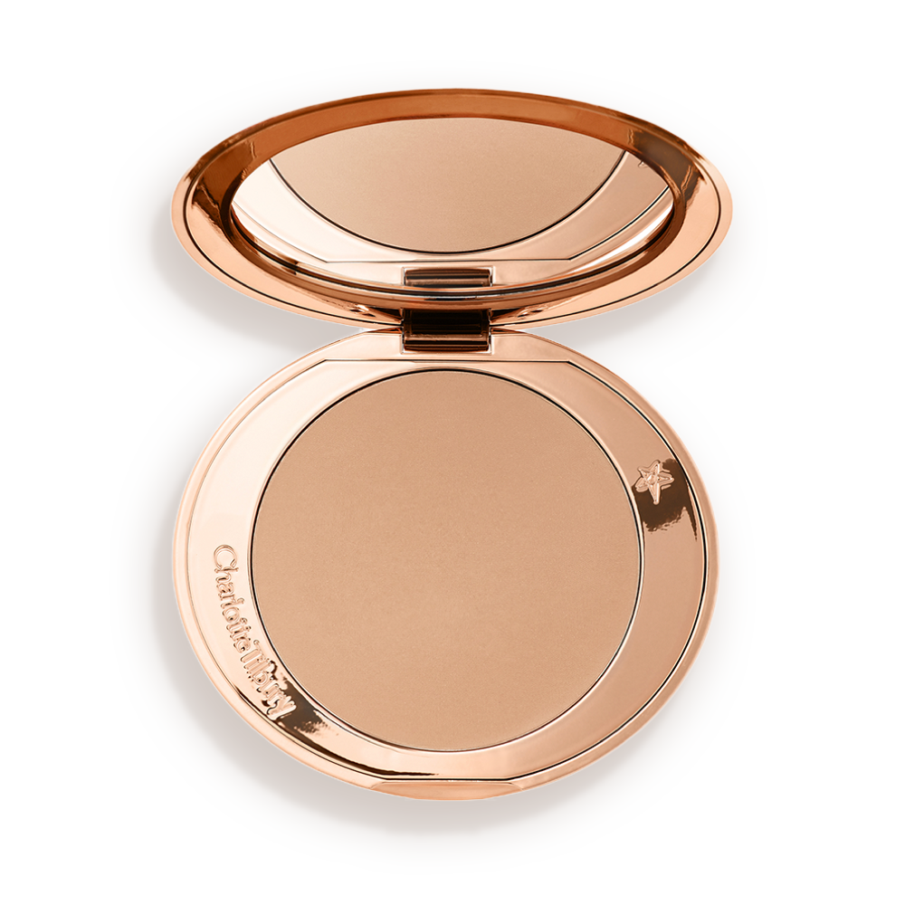 An open mirrored-lid bronzer compact in a light shade. 